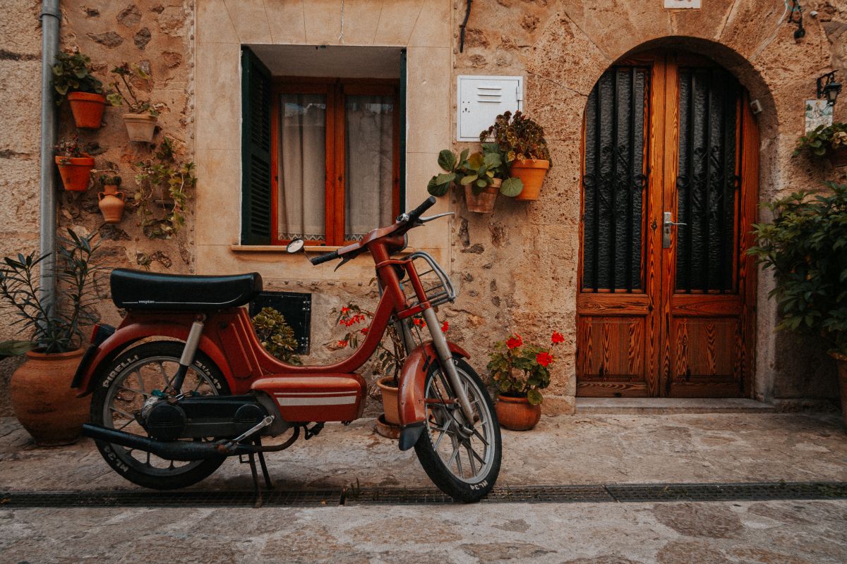 Orangenes Mofa vor eine Finka auf Mallorca im Spätsommer