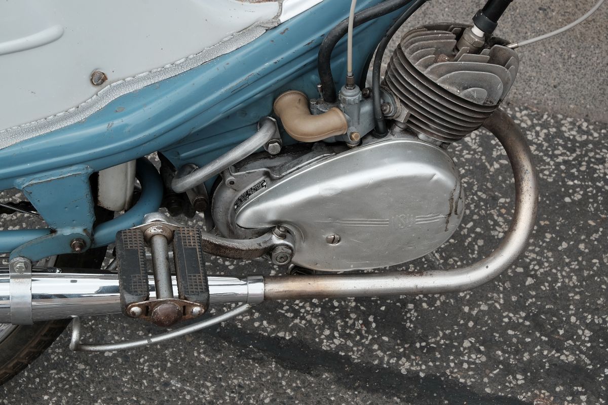 Blick auf ein altes aber sehr gepflegtes Mofa. Die Auspuffanlage hat einige Dellen, ist aber sauber und ohne grobe Verschmutzungen