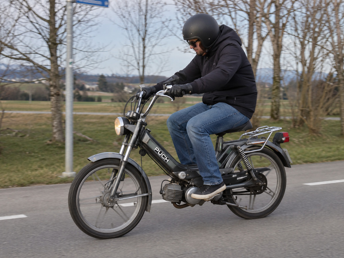 Un homme fait l'essai d'un vélomoteur Puch