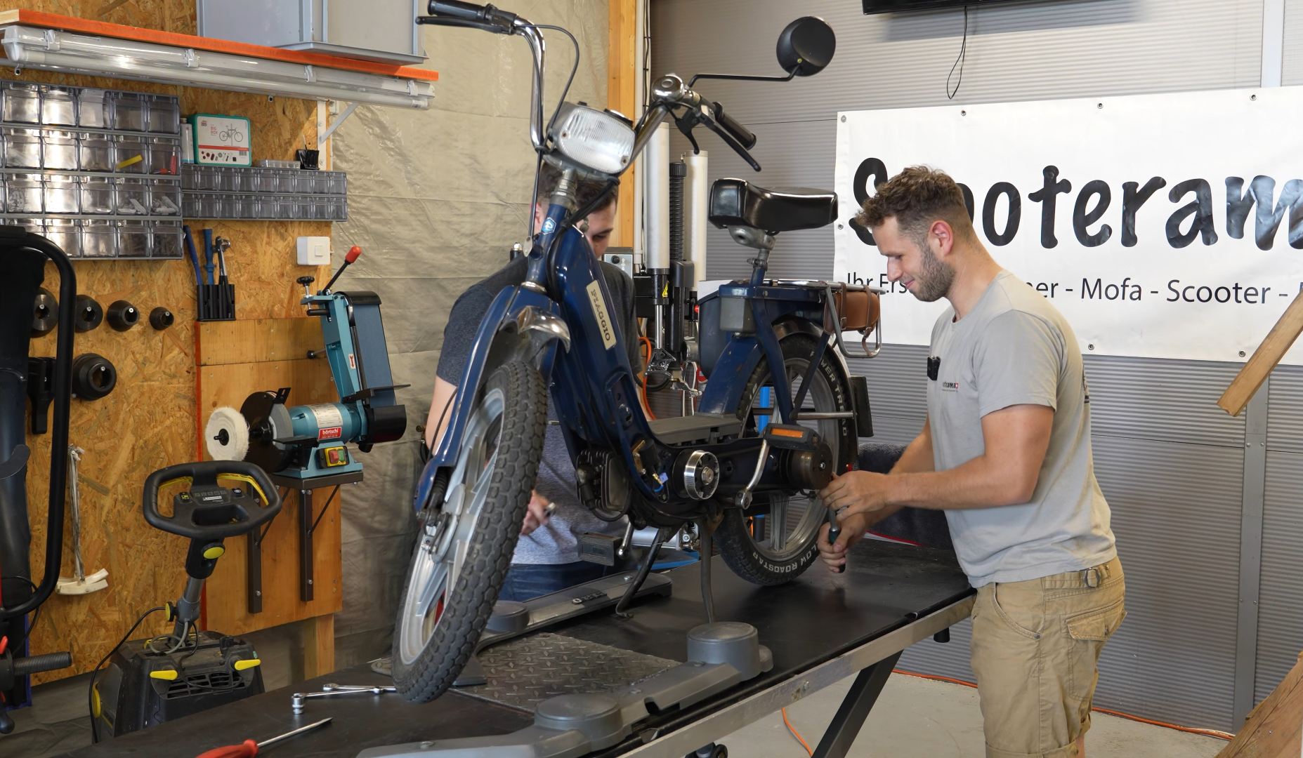 Ein sicherer Stand und eine saubere Umgebung sind essentiell für die Arbeit an der Variomatik, denn Schmutz sorgt für schnelleren Verschleiss. Toeffli steht auf einem sicheren Untergrund auf dem Hauptständer, 2 Männer arbeiten daran